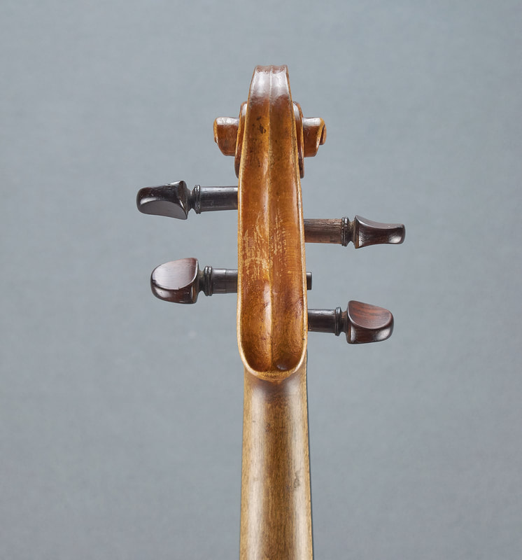 The scroll of an antique, handmade Dresden Violin (back view).